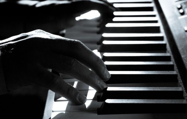 Black-and-white close-up of a hand playing piano keys